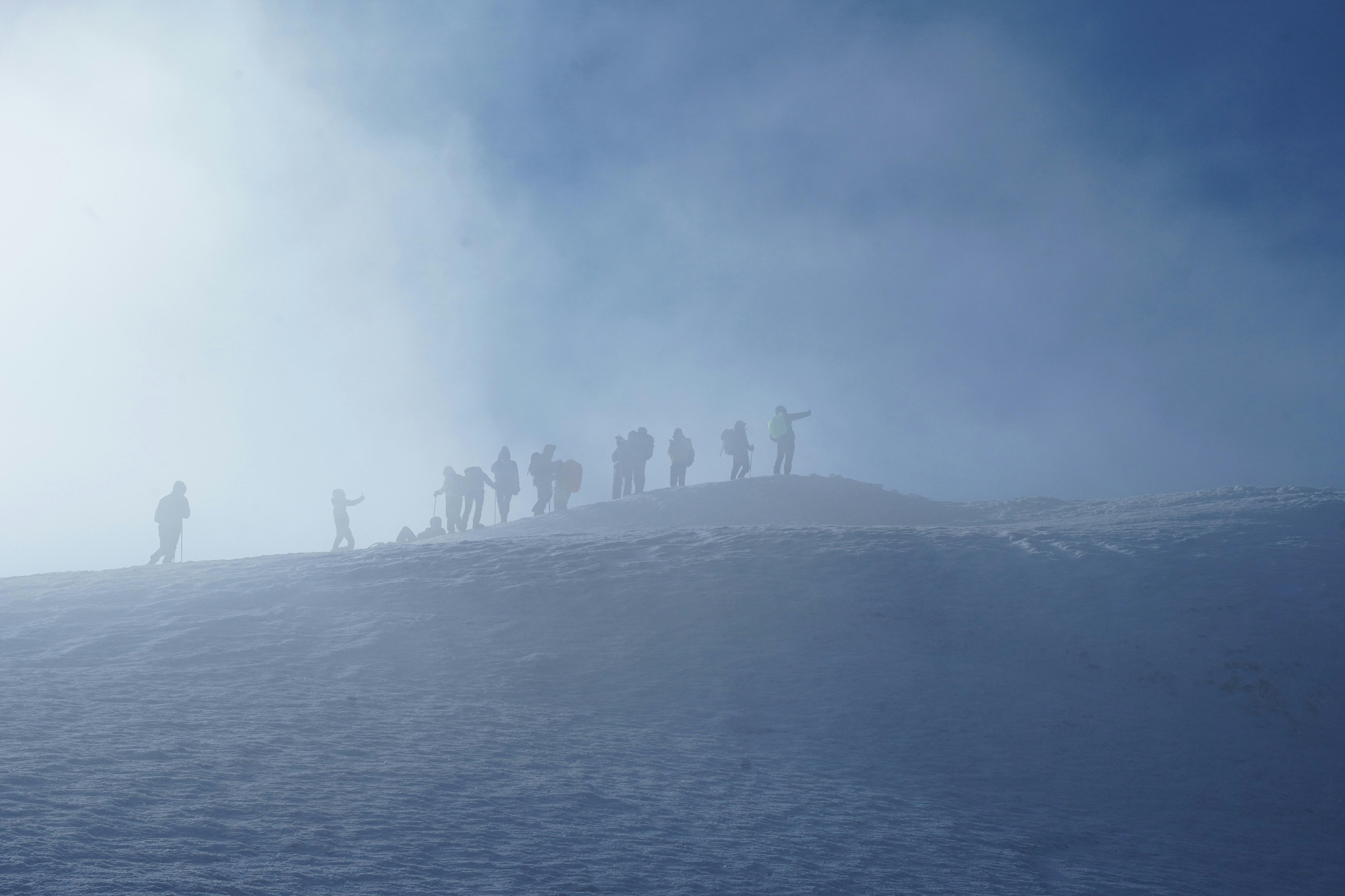 a group of people standing on top of a snow covered slope